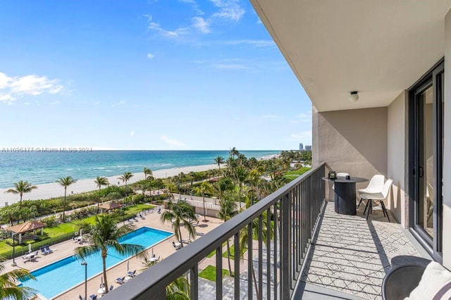 balcony featuring a beach view and a water view