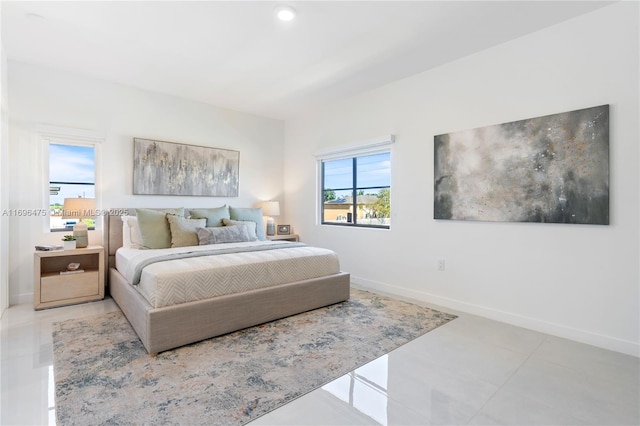 bedroom with light tile patterned floors and baseboards