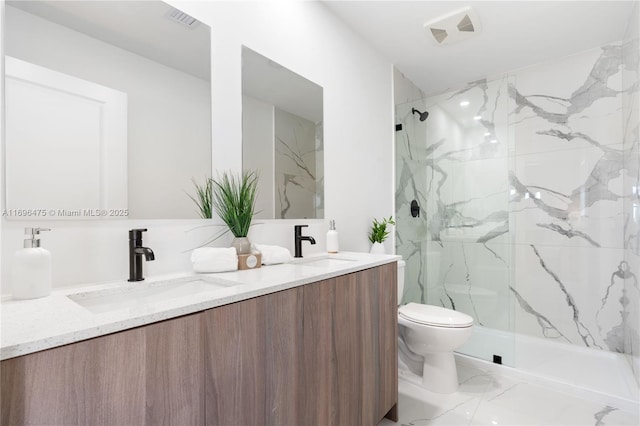 full bath featuring double vanity, a marble finish shower, toilet, and a sink