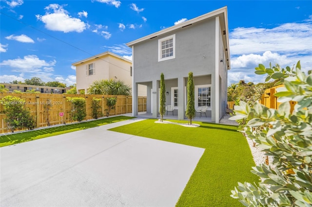 back of house featuring a patio area and a yard