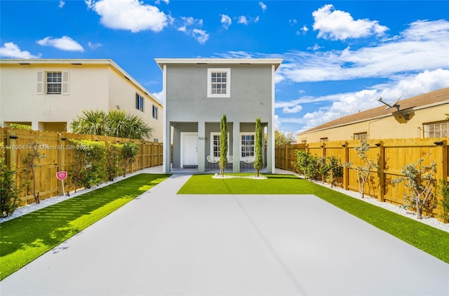 rear view of house featuring a lawn and a patio area