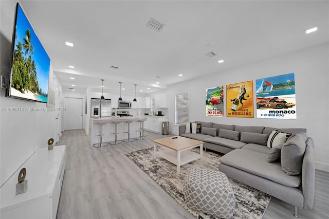 living room with light hardwood / wood-style floors and sink