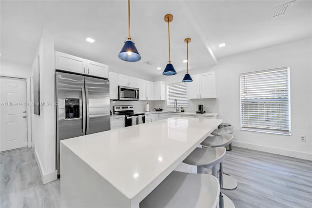 kitchen featuring sink, a center island, light wood-type flooring, and appliances with stainless steel finishes