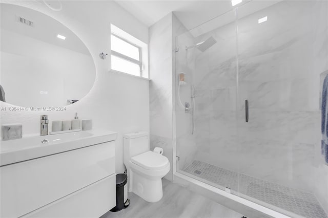 bathroom with hardwood / wood-style flooring, toilet, vanity, and walk in shower