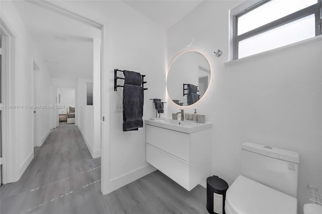 bathroom with hardwood / wood-style flooring, vanity, and toilet