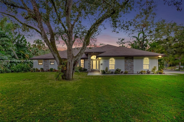 single story home featuring a lawn