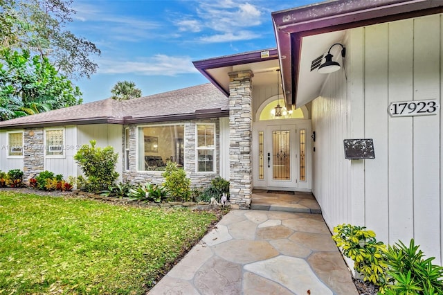 view of exterior entry with a yard