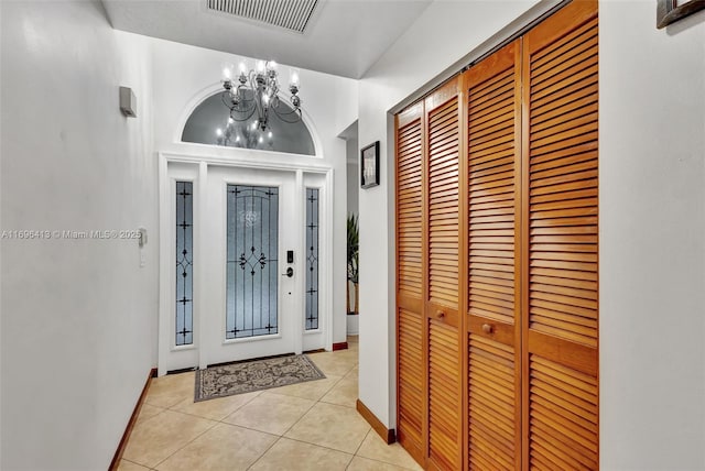 tiled entrance foyer featuring a notable chandelier