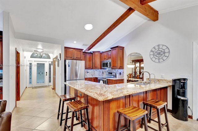 kitchen with stainless steel appliances, a kitchen breakfast bar, kitchen peninsula, and lofted ceiling with beams