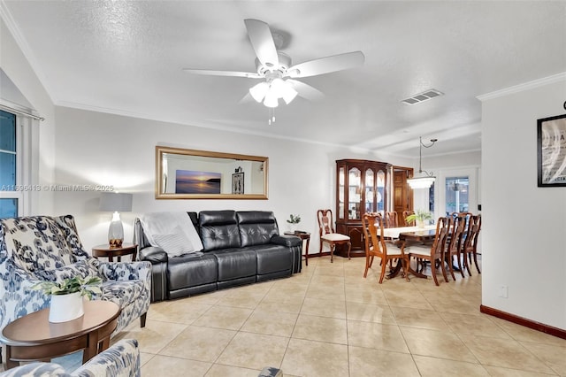 living room featuring ceiling fan, ornamental molding, a textured ceiling, and light tile patterned flooring