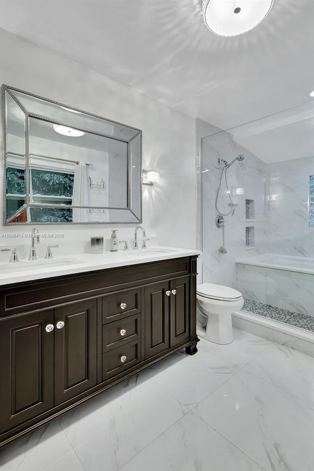 bathroom with vanity, tiled shower, and toilet