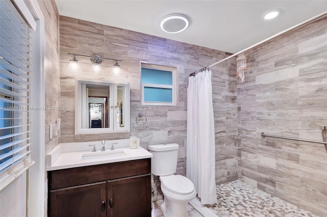 bathroom featuring a shower with curtain, vanity, tile walls, and toilet