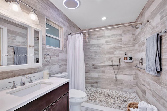 bathroom featuring vanity, toilet, tile walls, and a shower with curtain