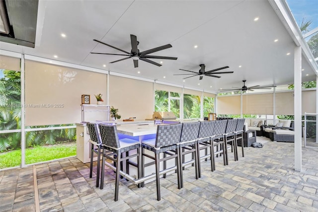 view of patio / terrace with outdoor lounge area, area for grilling, ceiling fan, and a bar