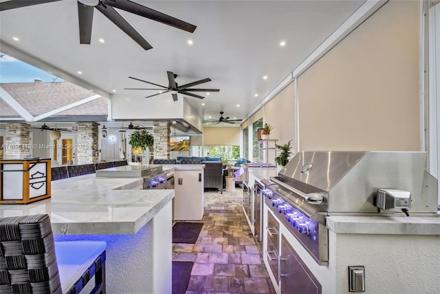 view of patio with ceiling fan, a grill, exterior kitchen, and an outdoor bar