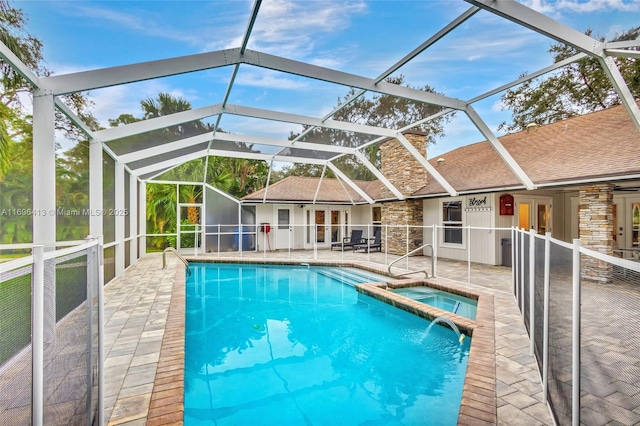 view of pool with an in ground hot tub, a lanai, pool water feature, and a patio