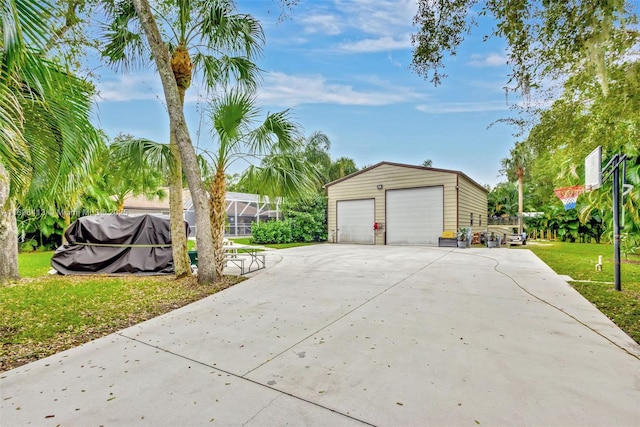 view of home's exterior featuring an outbuilding, a garage, a lanai, and a lawn