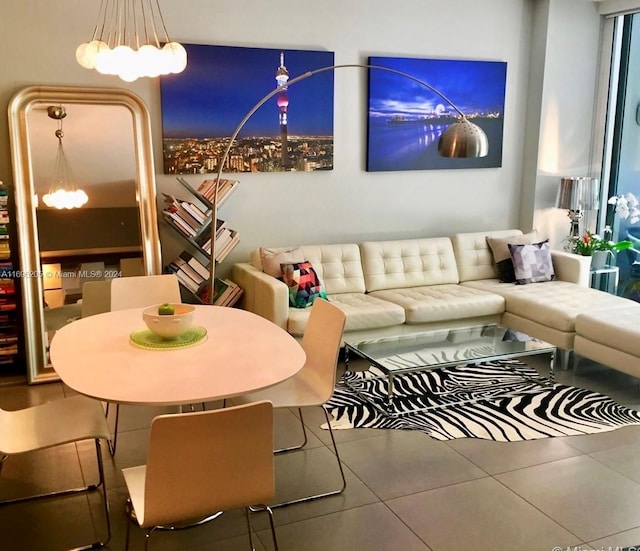 tiled living room with a notable chandelier