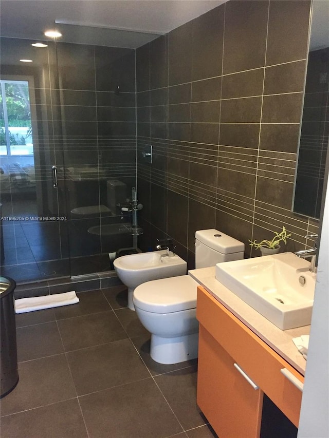 bathroom with tile patterned flooring, toilet, a shower with door, vanity, and tile walls