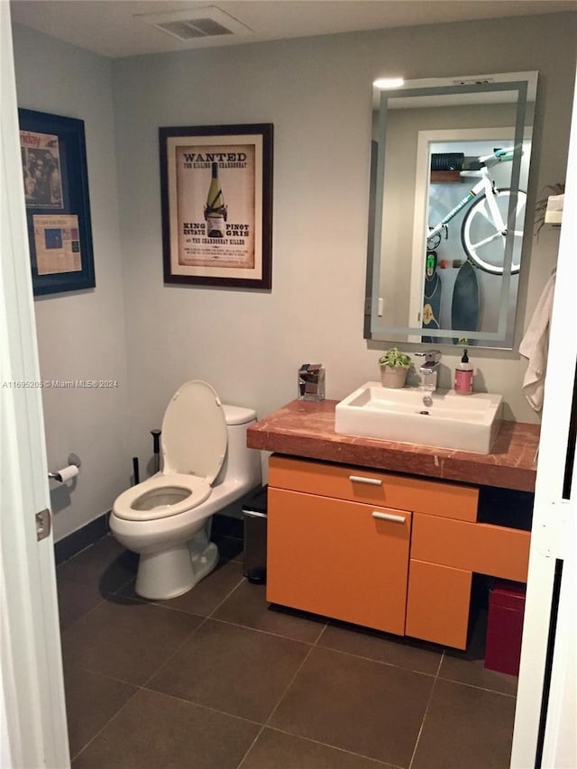 bathroom with tile patterned flooring, vanity, and toilet