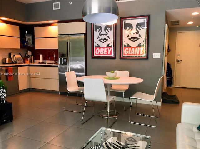 dining space with dark tile patterned flooring and sink