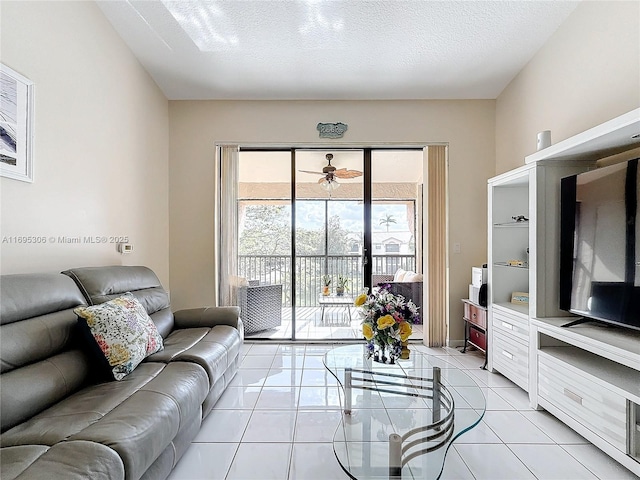 living room featuring light tile patterned floors, a textured ceiling, and ceiling fan