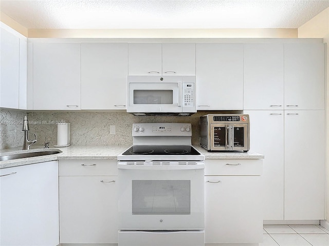 kitchen with white cabinets, backsplash, white appliances, and sink