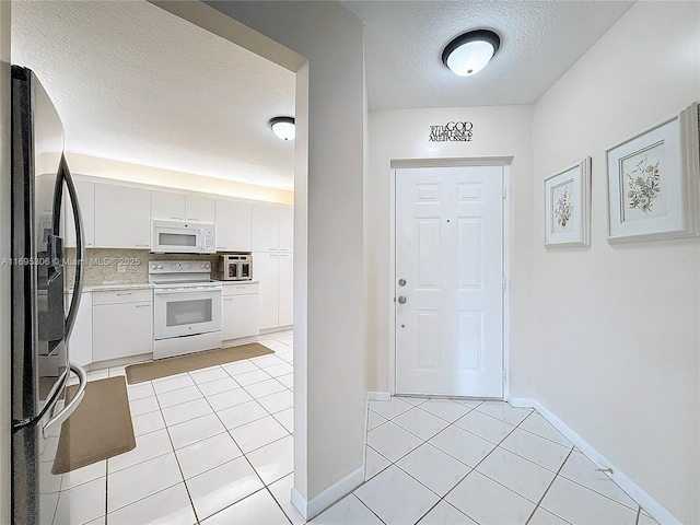 foyer with light tile patterned flooring and a textured ceiling