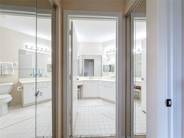 bathroom with tile patterned flooring, vanity, and toilet