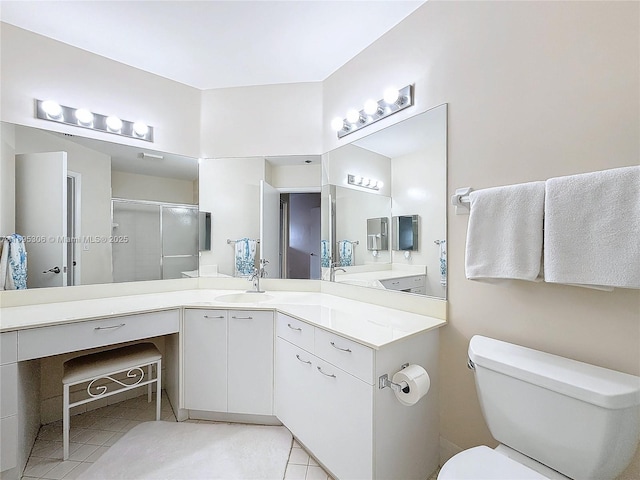 bathroom featuring tile patterned flooring, vanity, toilet, and walk in shower