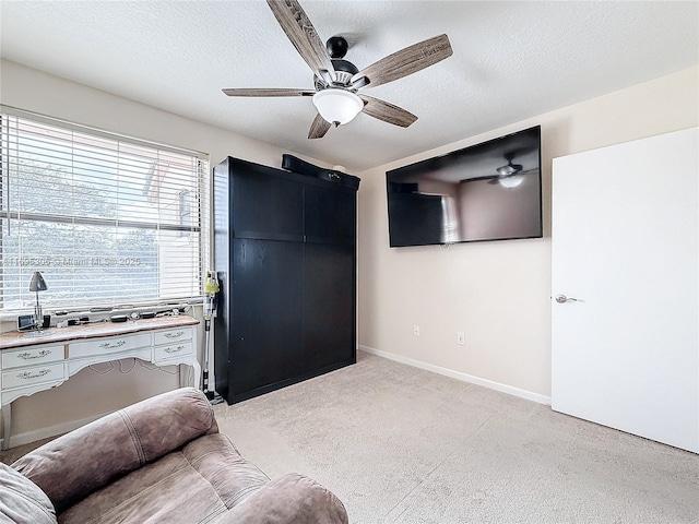 interior space with ceiling fan, light colored carpet, and a textured ceiling