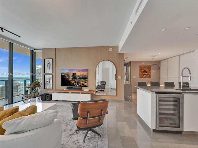 living room featuring expansive windows, indoor wet bar, and wine cooler