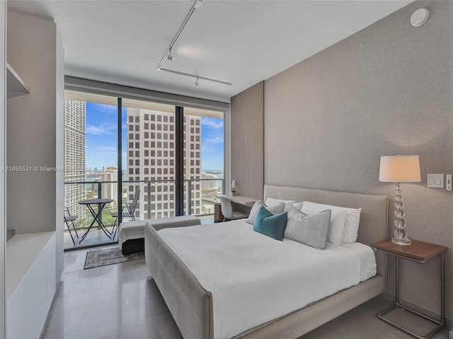 bedroom featuring expansive windows and access to outside