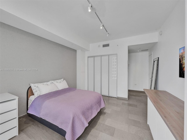 bedroom with a closet and track lighting