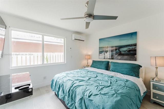 bedroom with hardwood / wood-style floors, an AC wall unit, multiple windows, and ceiling fan