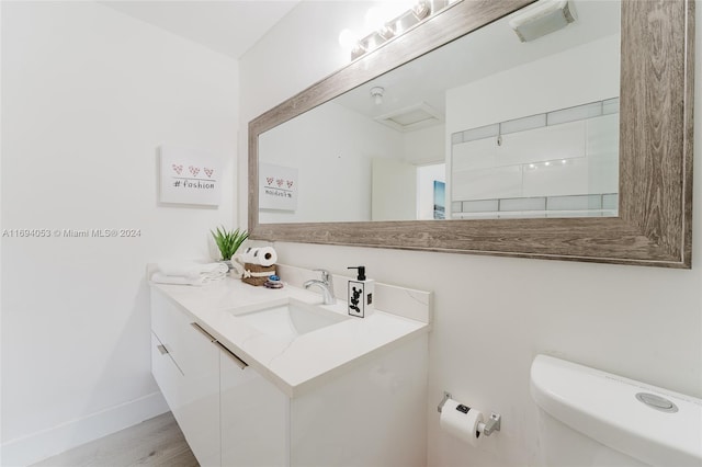 bathroom with vanity, toilet, and wood-type flooring