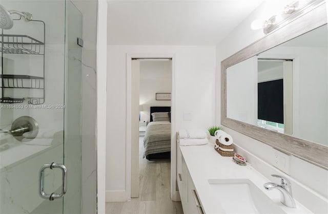 bathroom featuring vanity, wood-type flooring, and walk in shower