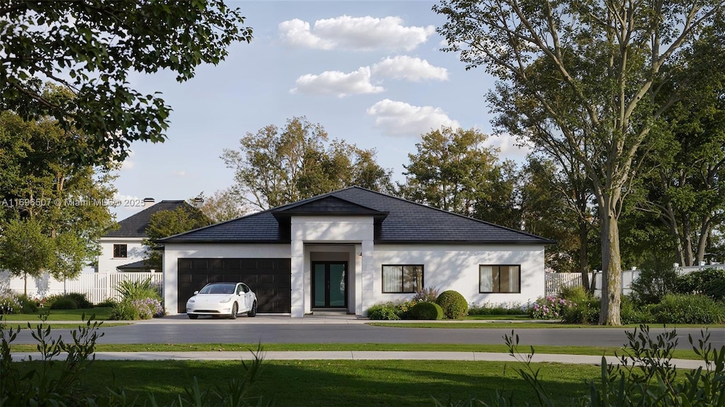 exterior space with a front yard, a garage, aphalt driveway, fence, and stucco siding