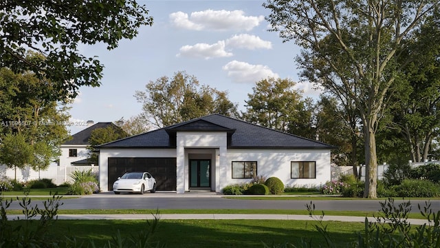 exterior space with a front yard, a garage, aphalt driveway, fence, and stucco siding