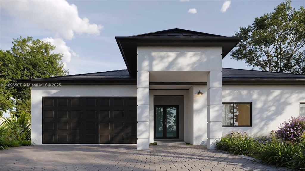 view of front of property featuring a garage, stucco siding, and driveway