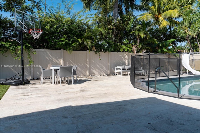 view of pool featuring a water slide and a patio