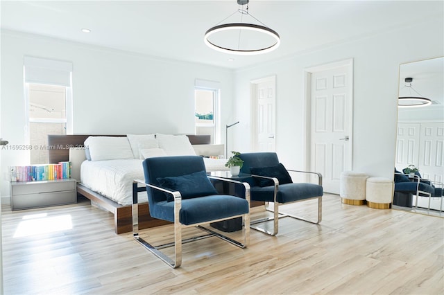 bedroom with light hardwood / wood-style flooring and crown molding