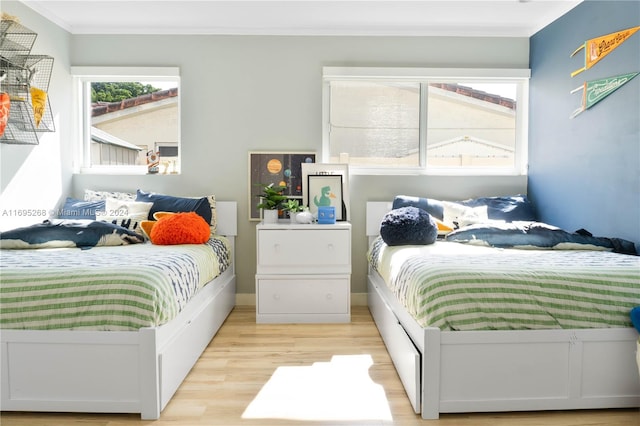 bedroom featuring light wood-type flooring and crown molding