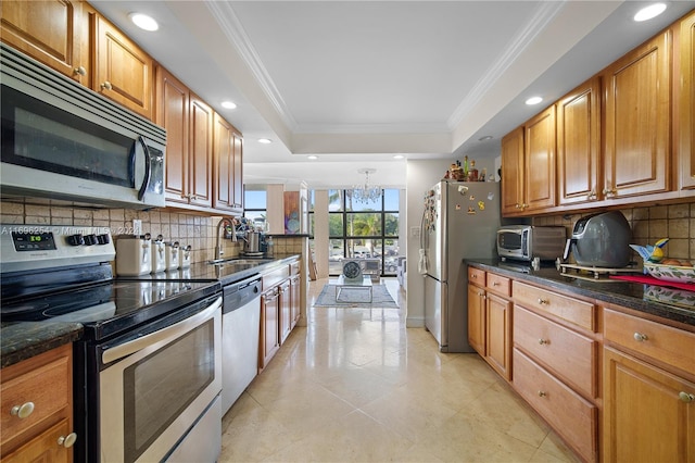 kitchen featuring sink, tasteful backsplash, a chandelier, appliances with stainless steel finishes, and ornamental molding