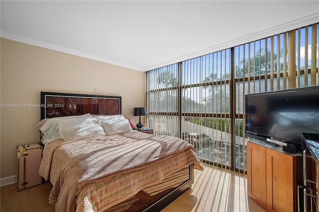 bedroom featuring access to exterior, crown molding, and light hardwood / wood-style flooring