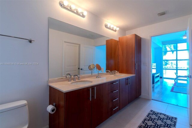 bathroom with tile patterned flooring, vanity, and toilet