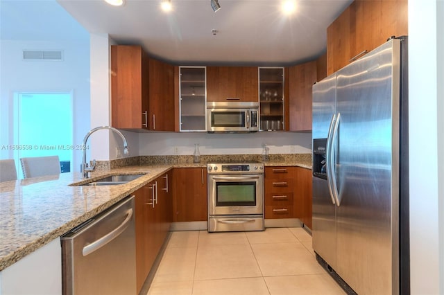 1945 S Ocean Dr Unit M5, Hallandale Beach, FL 33009 - kitchen with appliances with stainless steel finishes, a sink, light stone countertops, and brown cabinetry