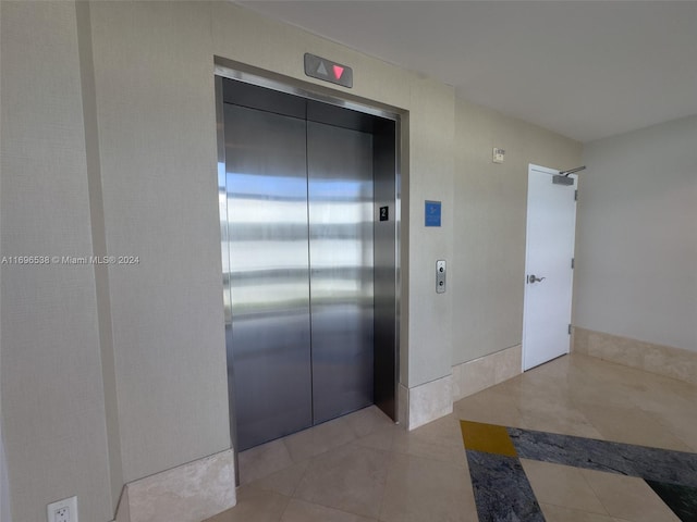 hall featuring light tile patterned floors and elevator