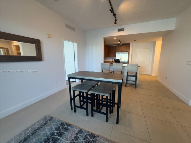1945 S Ocean Dr Unit M5, Hallandale Beach, FL 33009 - dining space featuring rail lighting, light tile patterned flooring, and baseboards