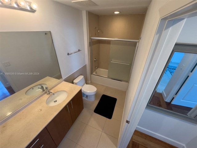 full bathroom with tile patterned flooring, vanity, toilet, and shower / bath combination with glass door